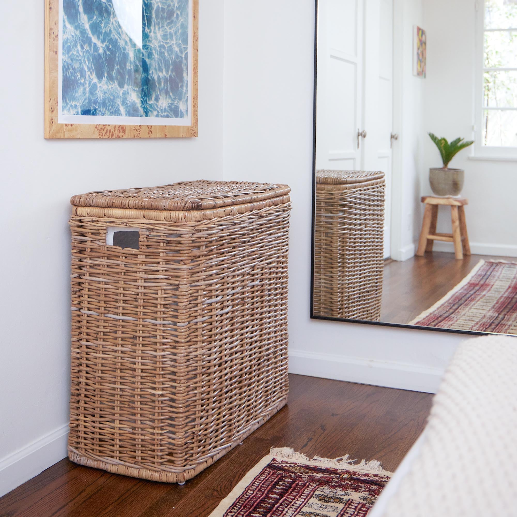 3-Compartment Kubu Wicker Laundry Hamper in Serene Grey shown in bedroom with dark wood floors | The Basket Lady